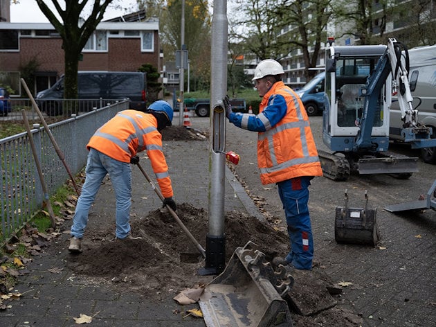 men in orange vests working on a pole men in orange vests working on a pole